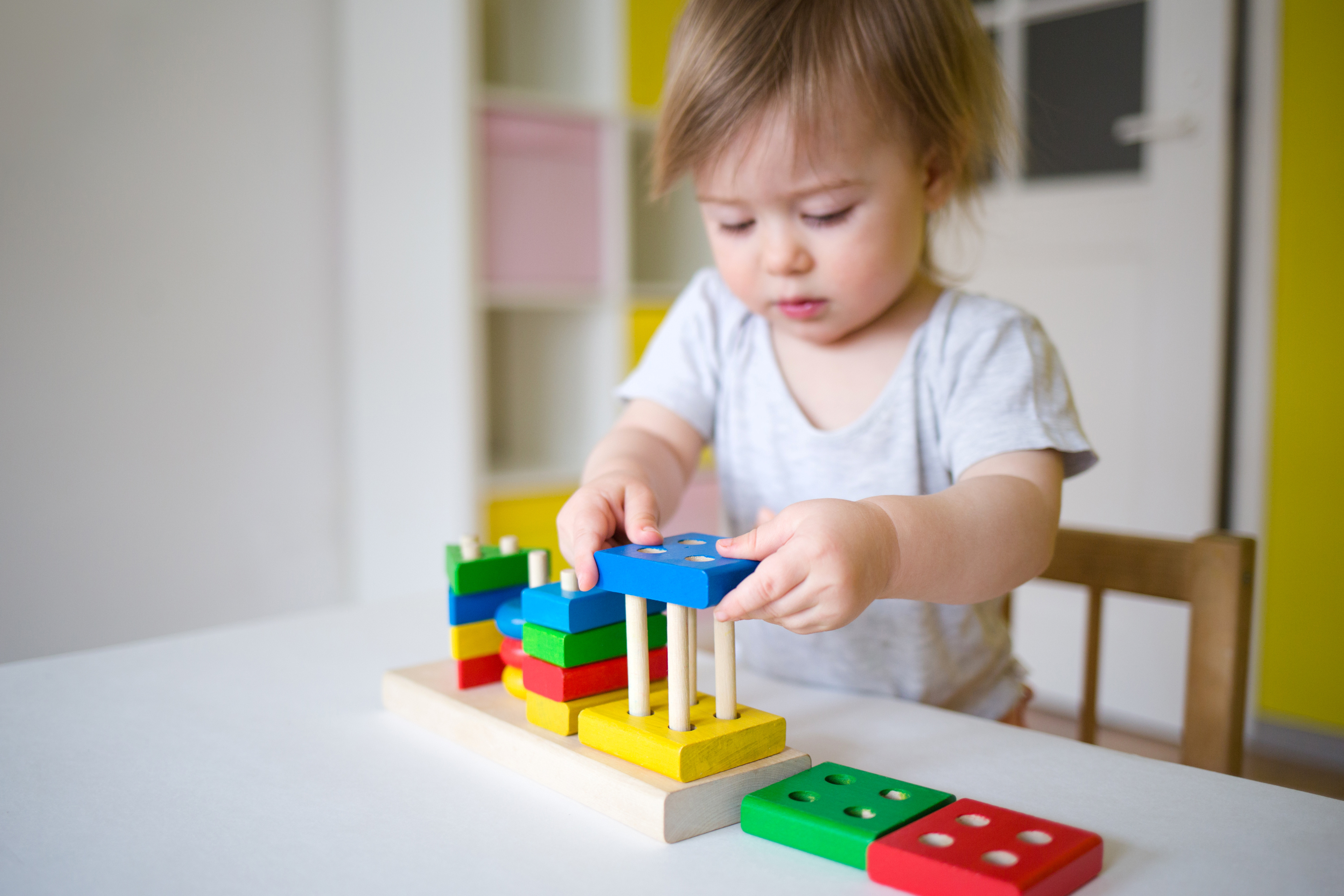 Baby Plays In The Constructor. Small Child Puts The Rings On The Pins. Concept Of Development Of Fine Motor Skills