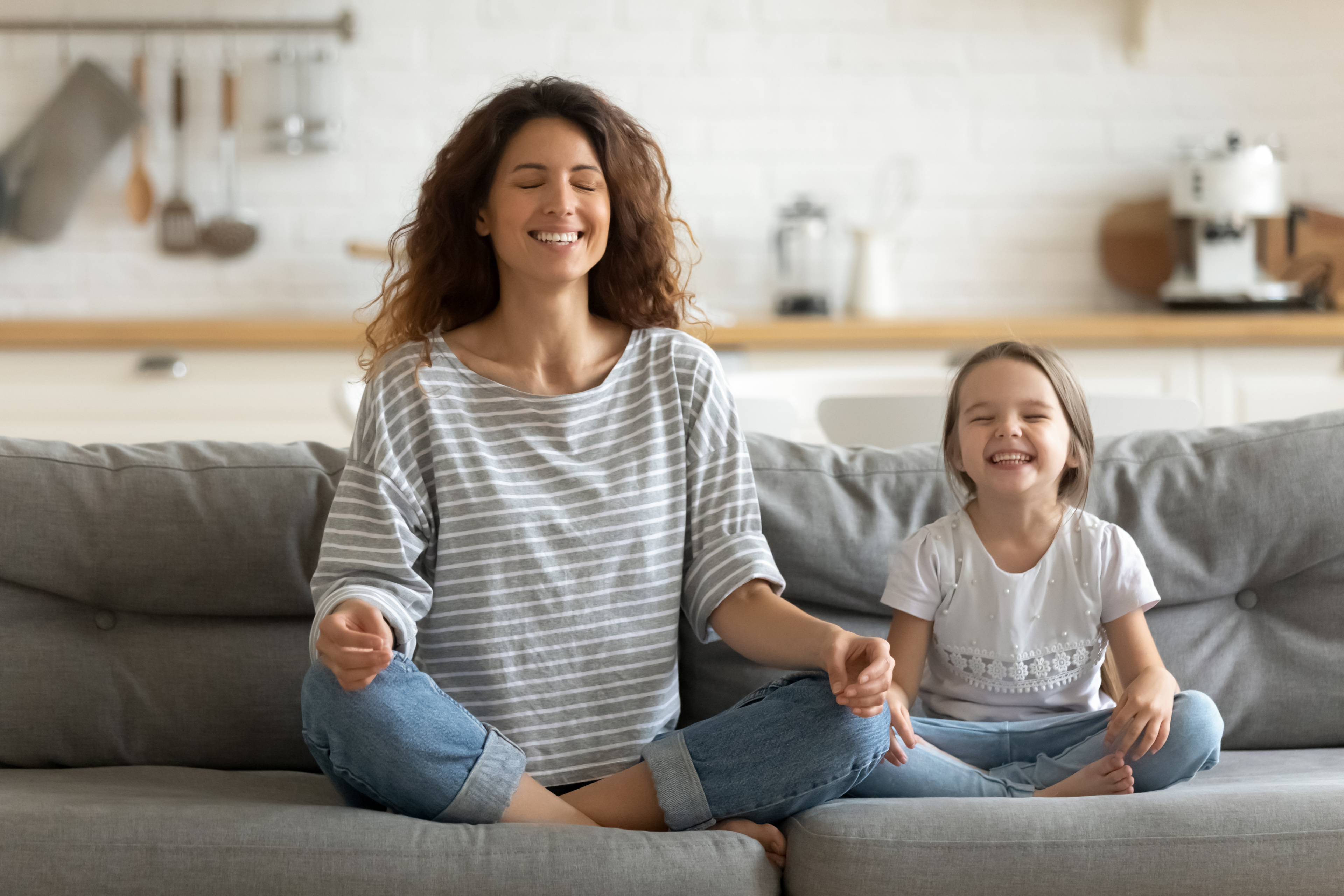 Happy Young Nanny Mom Teaching Small Daughter Yoga Breathing Exercise.